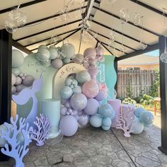 there are balloons and other decorations on the outside of this tented area for an ocean themed birthday party