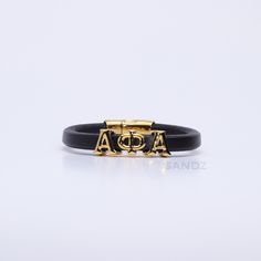 Elevate your Alpha Phi Alpha paraphernalia collection with our exclusive handcrafted bracelet made with genuine Spanish leather and 316 Stainless Steel! Prophyte 2.0 men's bracelets by SANDZ. We have reimagined the aesthetics of our original version of this bracelet while upgrading the materials to ensure durability and longevity without compromising style. DESIGN ENHANCEMENTS *Bold & Distinctive: Reimagined Greek letter motif exclusive to SANDZ. *Elegant Appearance: Elevated lines, curves, and Luxury Adjustable Engraved Leather Bracelet, Luxury Adjustable Black Band Bracelet, Luxury Black Engraved Leather Bracelet, Luxury Engraved Black Leather Bracelet, Luxury Black Leather Engraved Bracelet, Personalized Black Leather Bracelets, Personalized Black Leather Jewelry, Black Symbolic Engraved Bracelets, Symbolic Black Engraved Bracelets