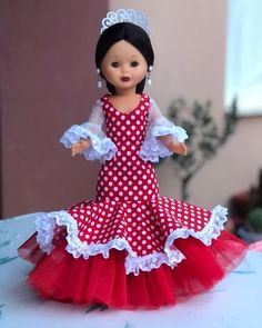 a doll is wearing a red and white polka dot dress