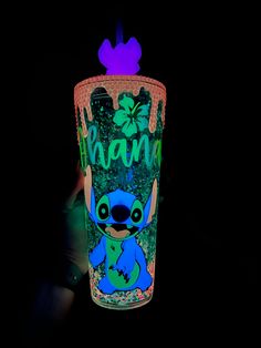 a lit up glass with the word mama painted on it in front of a black background