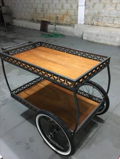 a wooden cart with wheels and an intricate design on the front is sitting in a warehouse