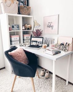 a white desk topped with a laptop computer sitting on top of a wooden chair next to a book shelf