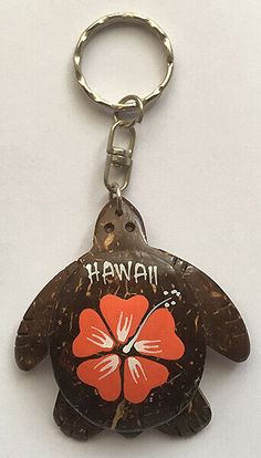 a hawaiian turtle keychain with the word hawaii on it's shell and an orange flower