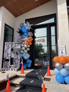 an entrance decorated with blue, orange and silver balloons