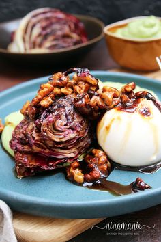 a blue plate topped with food next to two bowls filled with sauce and nuts on top