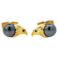 Crafted with the utmost precision and infused with regal splendor, these 18k yellow gold cufflinks exude an aura of strength and sophistication. At their heart lies the majestic visage of an eagle, its fierce gaze captured in intricate detail and rendered with exquisite artistry. The head of the eagle, fashioned from lustrous 18k yellow gold, commands attention with its noble bearing and commanding presence. Every curve and contour is meticulously crafted to convey the bird of prey's unmistakable majesty, from the curve of its beak to the texture of its feathers. Nestled below the eagle's gaze rests a hematite cabochon, its smooth surface a canvas for the interplay of light and shadow. The deep hue of the hematite exudes an aura of mystery and allure, drawing the eye and adding an element Emerald Eyes, Gold Eagle, Gold Cufflinks, An Eagle, The Eagle, Birds Of Prey, Precious Gemstones, Light And Shadow, Eagles