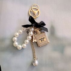 Gorgeous Keychain!!!. High Quality “Parfum N5” Rhinestone Keychain With Bow, Eiffel Tower Charm And White Faux Pearls. Sooooo Stunning!!! Brand New In Packaging. Luxury Keychain Aesthetic, Gifts For Rich People, Cute Car Keys Keychains Ideas, Cute Key Rings, Cherry Keychain, Pearl Keychain, Luxury Keychain, Designer Charms, Cars Accessories