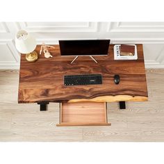 a wooden desk with a computer on top of it and a lamp next to it