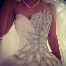 a woman wearing a wedding dress with beading on it