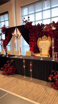 a table set up with candles and flowers for a formal function in front of large windows