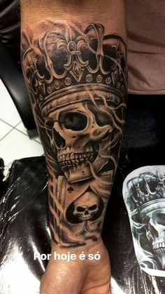 a man with a skull and crown tattoo on his arm