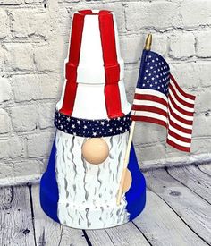 a patriotic gnome with an american flag on it's head, holding a stick