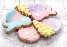 a glass plate topped with lots of decorated cookies