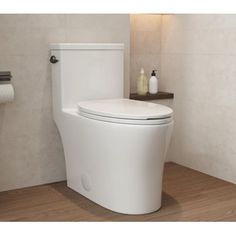 a white toilet sitting on top of a hard wood floor next to a roll of toilet paper