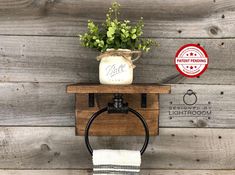 a towel rack with a potted plant on top and a white striped towel hanging from it