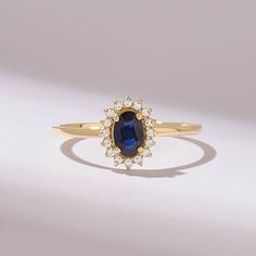 This captivating engagement ring features a lustrous navy blue gemstone at its center, encircled by a sparkling halo of brilliant diamonds. The exquisite combination of the oval sapphire and shimmering diamonds creates a timeless and elegant design, perfect for symbolizing love and commitment.  𝐈𝐭𝐞𝐦 𝐃𝐞𝐭𝐚𝐢𝐥𝐬 * Gold KT: 10K, 14K, 18K * Custom Gold Color: Rose Gold, Yellow Gold, White Gold * Top of Band: 9.30MM * Width of Band: 1.35MM * Thickness of Band: 1.10MM * Total Ctw: 0.45 ctw  𝐆 Blue Sapphire Engagement Ring Oval, Sapphire Engagement Ring Oval, Gemstone Solitaire Ring, September Birthstone Ring, Oval Halo Engagement Ring, Accented Engagement Ring, Engagement Ring Women, Blue Sapphire Engagement Ring, September Birthstone Rings