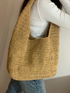 a woman carrying a yellow crocheted bag on her shoulder and wearing white shirt