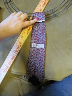 a person measuring the length of a necktie with a tape on top of it