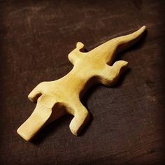 a wooden toy that is laying down on a brown tablecloth with a black background