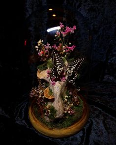 a vase filled with flowers and butterflies on top of a table