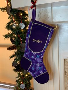 a purple christmas stocking hanging from the side of a fireplace