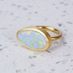 An amazing ring set with a one-off Mackeral Opal from Lightning Ridge, in 18ct Yellow Gold. Weight is 12.8 grams approx. Opal measures 22.6mm x 11.8mm approx. This ring is a size R in 18ct Yellow Gold with a matte finish. For a high-shine finish, please leave a note at checkout. Modern 14k Gold Opal Ring With Polished Finish, Modern Opal Ring In 14k Gold With Polished Finish, Polished Yellow Gold Opal Ring, Unique Yellow Gold Opal Ring With Polished Finish, Yellow Gold Opal Ring With Polished Finish For Wedding, Modern Oval Opal Wedding Ring, Modern Oval Opal Ring For Wedding, Modern Yellow Gold Oval Opal Ring, Modern Gold Oval Opal Ring