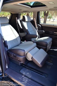 the interior of a vehicle with two seats and no steering wheel, in front of palm trees