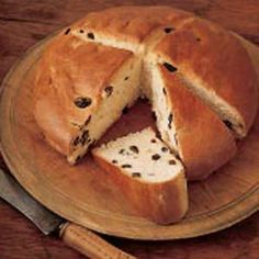 two slices of bread on a wooden plate with cheese and butter in the middle next to a knife