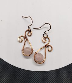 These earrings were made from copper wire and feature a genuine rose quartz stone bead in the center. The earring hooks are nickel free and copper colored to match. Adjustable Wire Wrapped Rose Gold Earrings, Adjustable Rose Gold Wire Wrapped Earrings, Rose Gold Wire Wrapped Copper Wire Earrings, Rose Gold Wire Wrapped Earrings In Copper, Rose Gold Wire Wrapped Earrings, Nickel Free Rose Gold Copper Wire Earrings, Nickel-free Rose Gold Copper Wire Earrings, Rose Quartz Earrings, Rose Quartz Stone