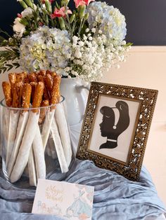 there is a vase with flowers and some pretzels in it next to a card