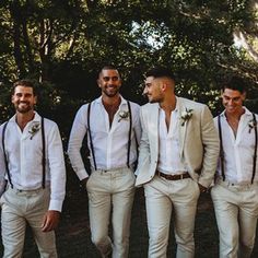 a group of men standing next to each other wearing white shirts and suspender ties