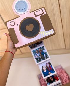 a person holding up a pink and brown camera