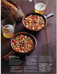 two bowls filled with soup sitting on top of a table next to a loaf of bread