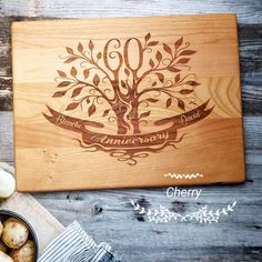 a cutting board with an engraved family tree on it next to some vegetables and utensils