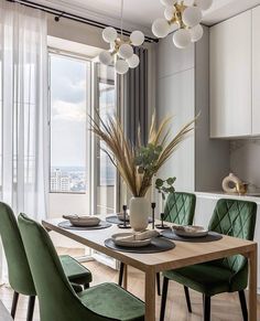 a dining room table with green chairs and a potted plant on top of it