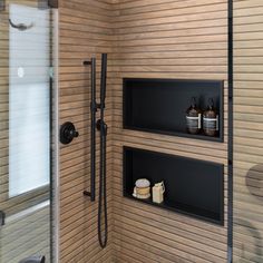 a shower with two shelves on the wall