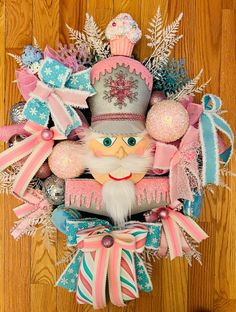 a wreath made to look like an old fashioned santa clause with pink and blue decorations