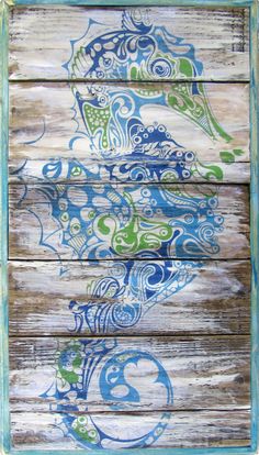 an old window painted with blue and green designs on wood planks in the shape of a fish