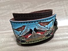 "This item is authentically handmade of genuine leather, the front has a photo digital image printed directly onto leather, produced in my studio. I've made this wrapping cuff out of soft leather, choose a black or brown base. Machine stitched, it has an attached elastic that hooks over a button, so this cuff will adjust to fit most wrist sizes 5.75\" to 7\" in circumference OR select a CUSTOM SIZE in the drop down menu. At the narrowest, the width of the cuff is 1.25\" and at the widest it's 2\ Leather Bracelets With Adjustable Band As Gift, Adjustable Leather Cuff Bracelet As Gift, Handmade Adjustable Leather Wristband, Handmade Adjustable Leather Bracelet For Everyday, Vintage Leather Strap Bracelet As Gift, Adjustable Handmade Leather Wristband, Adjustable Handmade Leather Bracelet, Handmade Adjustable Cuff Bracelet For Everyday Use, Vintage Handmade Bracelets For Everyday Use