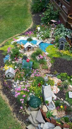 a garden with rocks and flowers in the middle, including a birdhouse on top