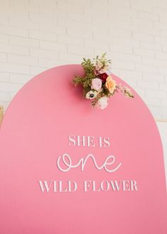 a pink sign that says she is one wild flower