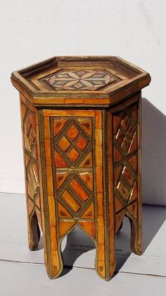 a small wooden table with an intricate design on it's top and bottom edge