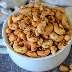 a white bowl filled with cashews on top of a table