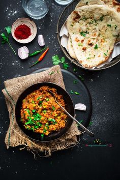 some food is sitting in a pan on a table with other dishes and utensils