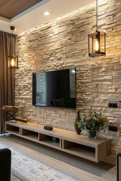 a living room with a stone wall and tv mounted on the side of it's wall