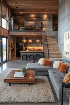 a living room filled with lots of furniture and a staircase leading up to the top floor