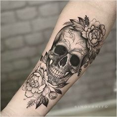 a skull with flowers on it's arm is shown in black and grey ink