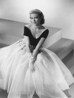 a black and white photo of a woman in a ball gown