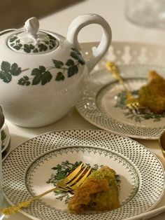 two plates with food on them and a tea pot