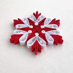 a snowflake made out of red and white paper